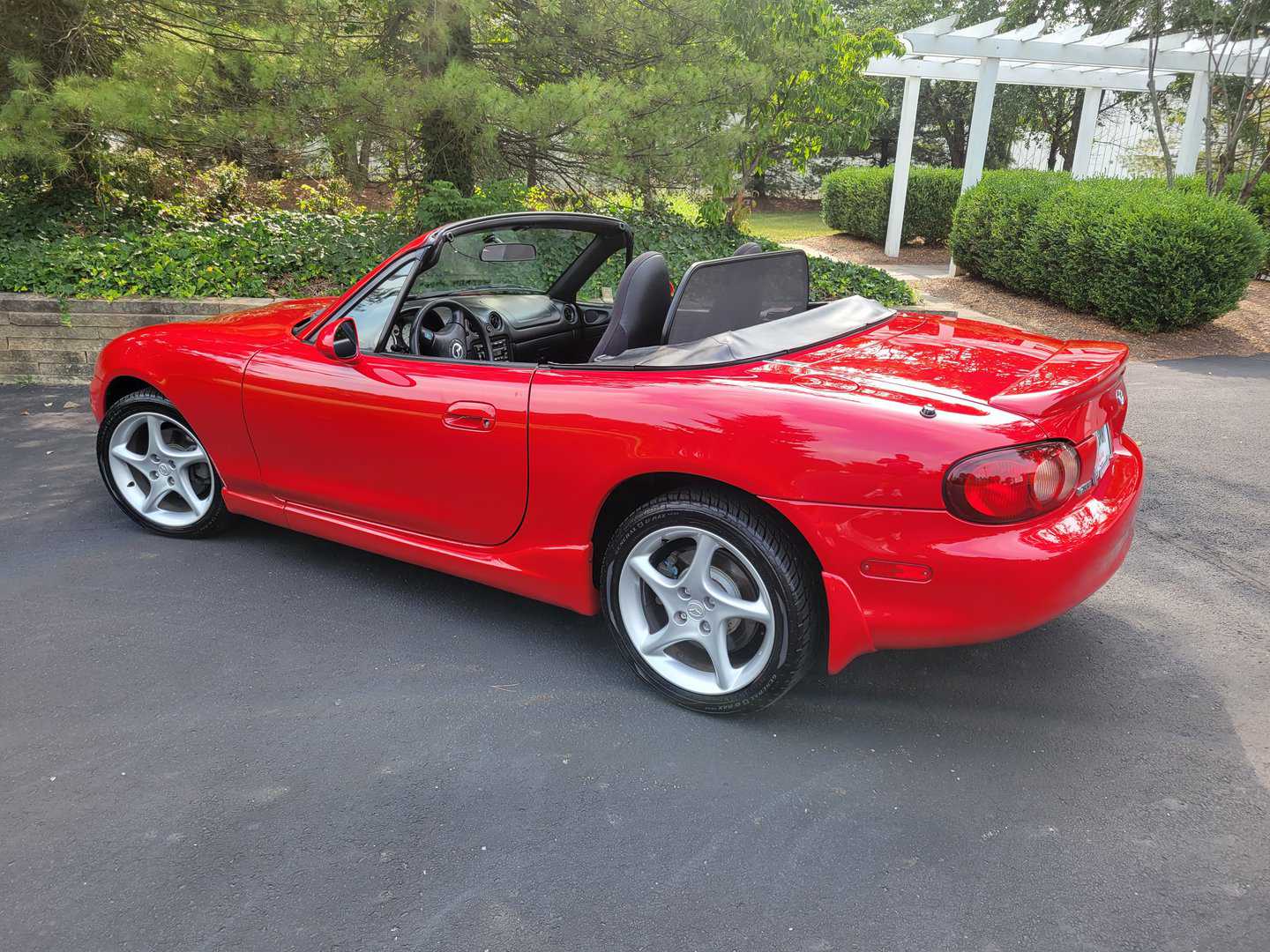 A red sports car is parked in a parking lot.