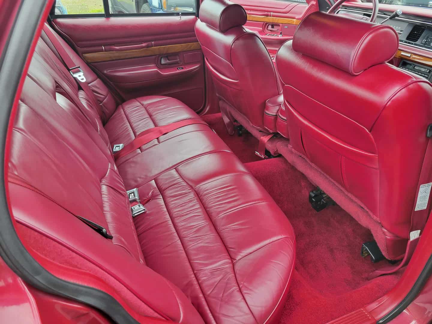 The interior of a red car with leather seats.