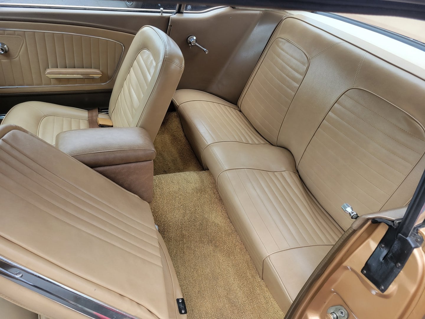 The interior of a 1965 Ford Mustang car with leather seats.