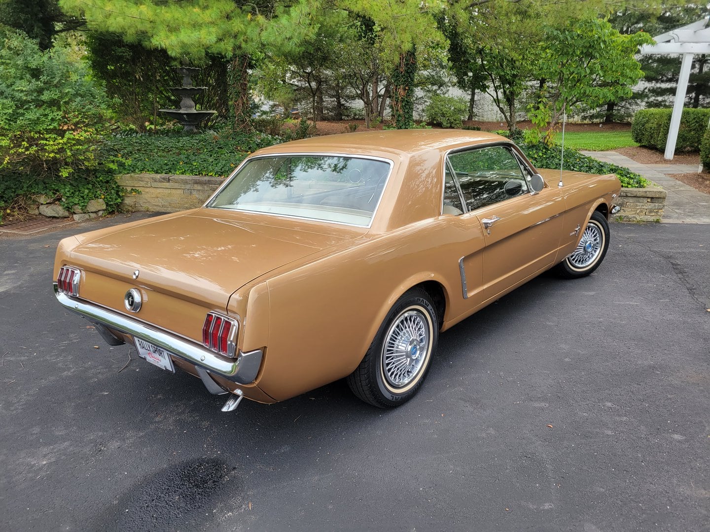 A 1965 Ford Mustang is parked in a parking lot.