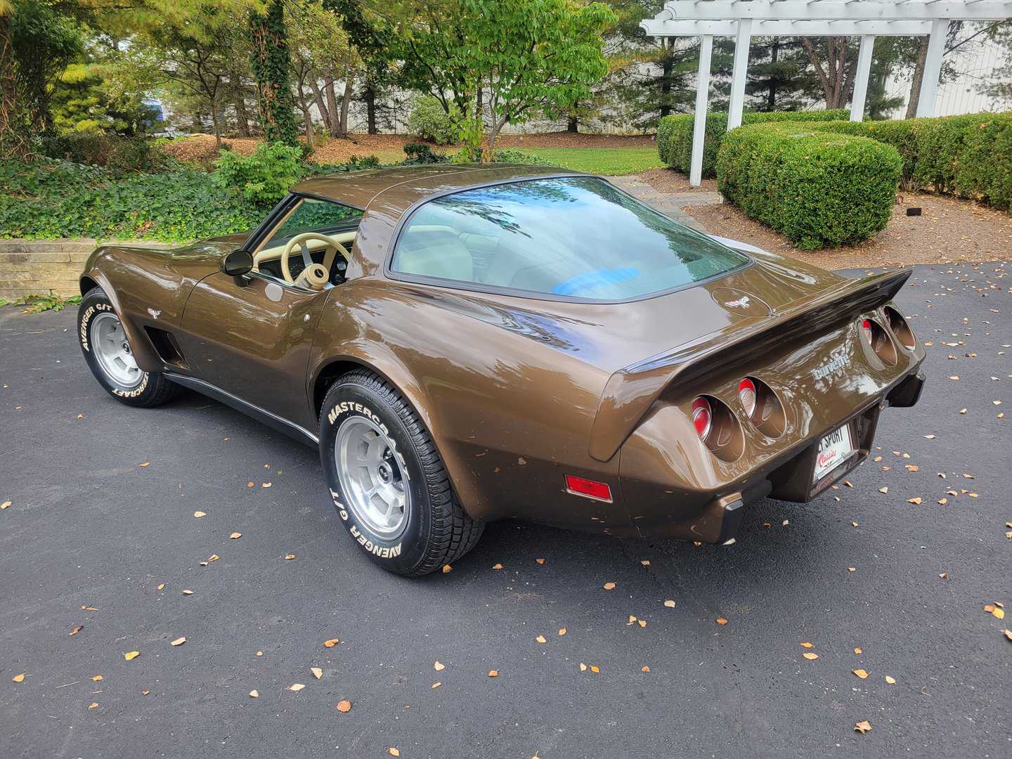 A 1979 brown chevrolet corvette parked in a driveway.