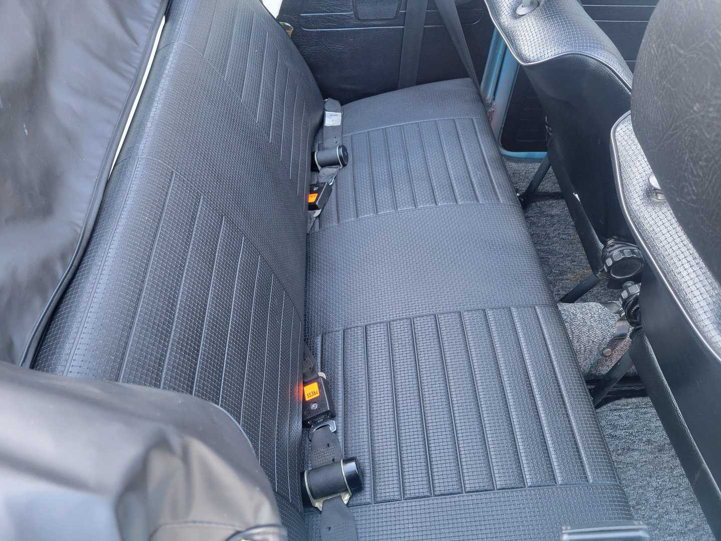 A 1979 Volkswagen Beetle Convertible featuring a secure back seat with a seat belt.