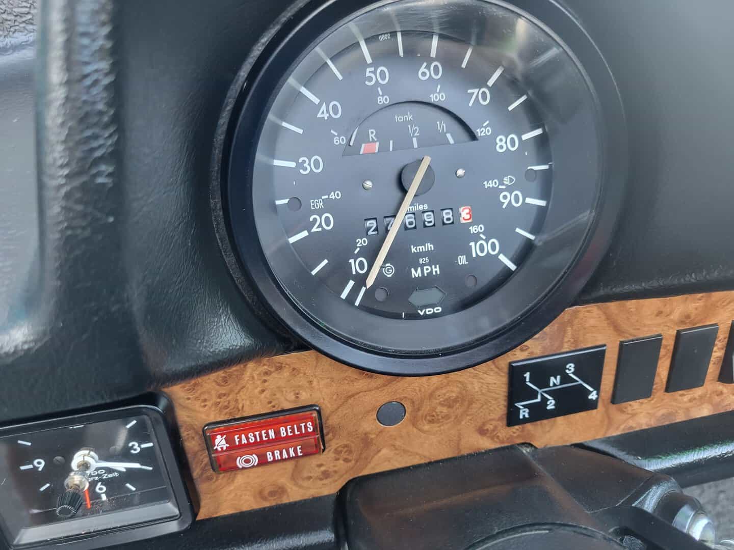 A 1979 Volkswagen Beetle Convertible dashboard showcasing a clock and gauges.