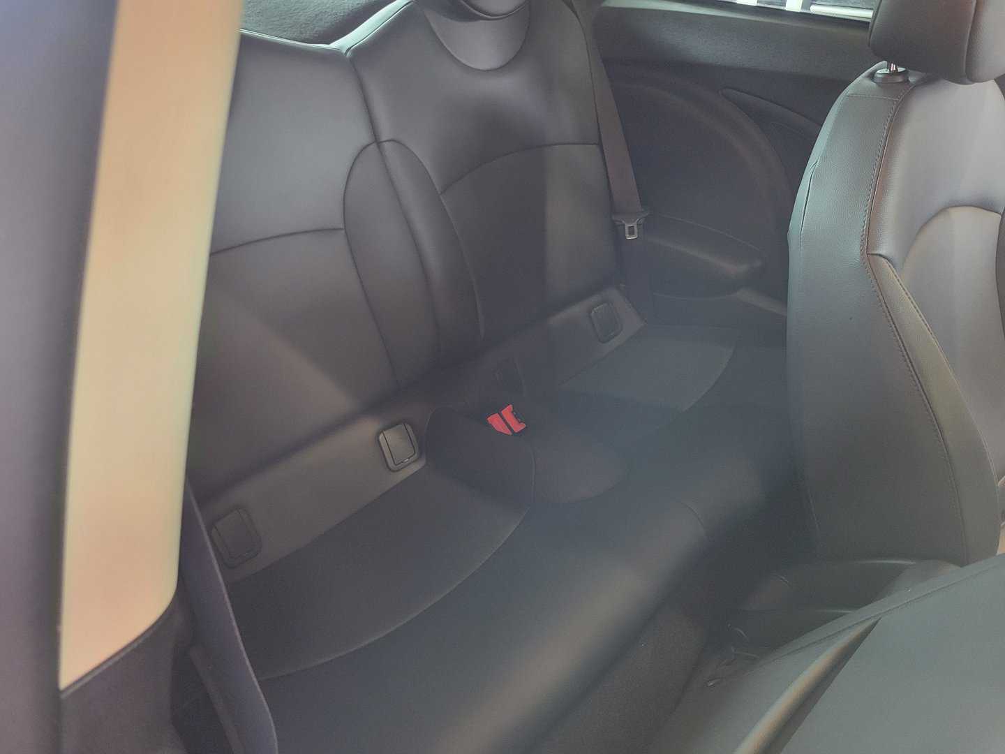 The black leather seats in the back of a 2013 Mini Cooper S.