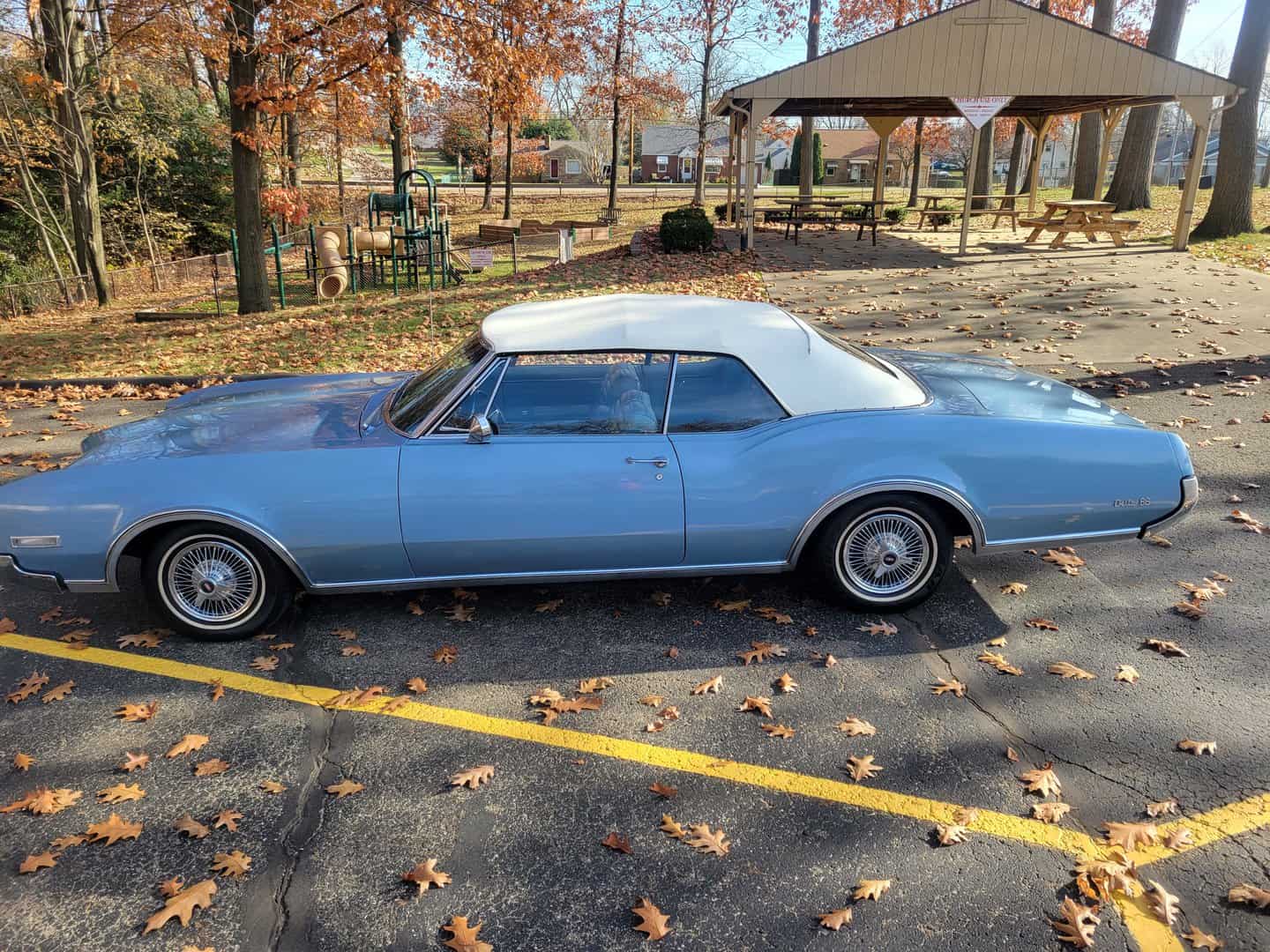 A 1967 Oldsmobile Delta 88 Convertible Parked In A Parking Lot.