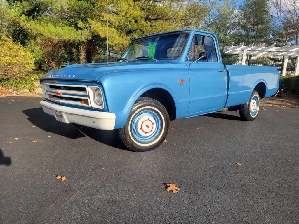 A Blue Chevrolet Pick Up Truck Is Parked In A Parking Lot.