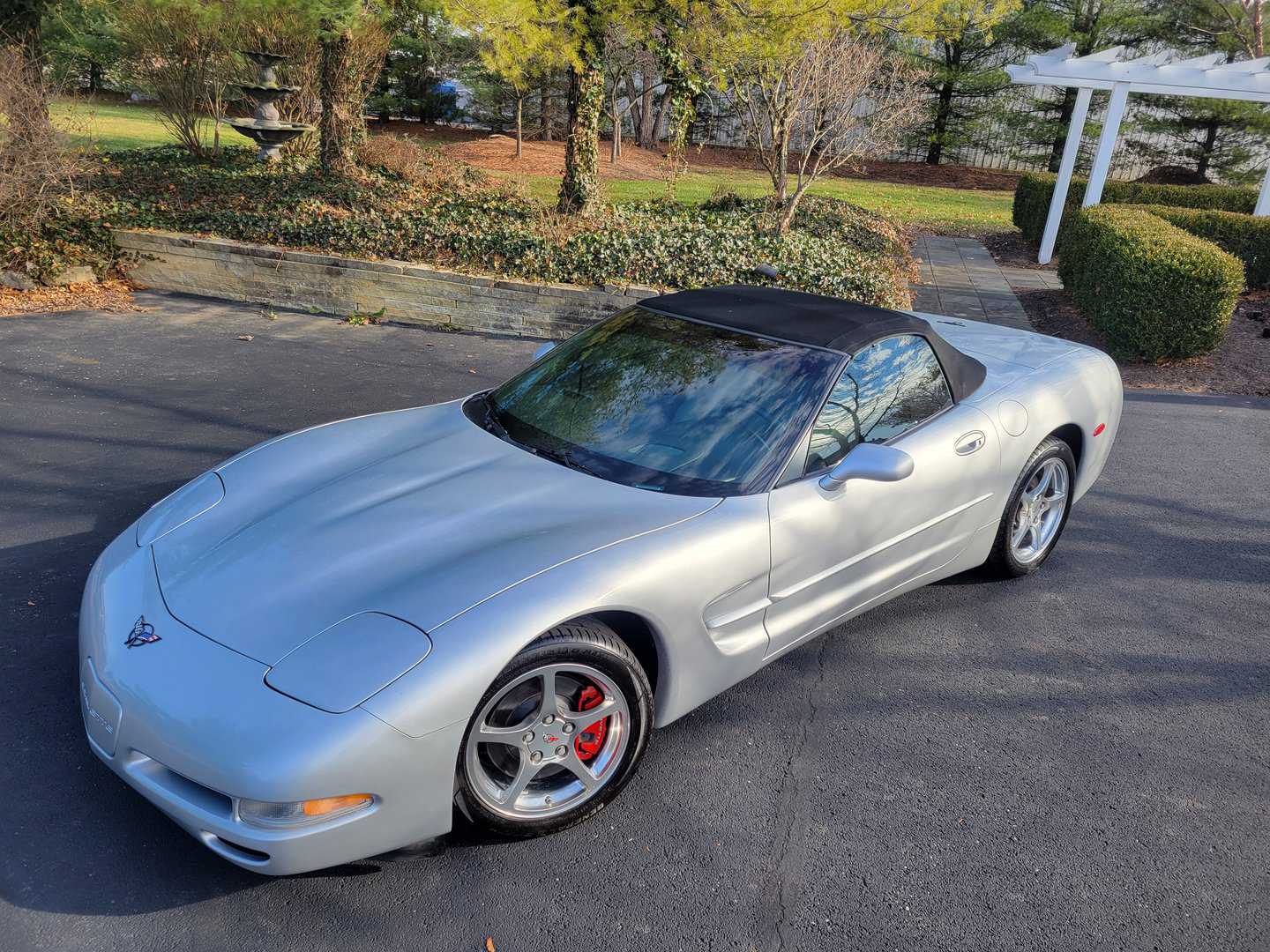A Silver 2001 Chevrolet Corvette Parked In A Driveway.