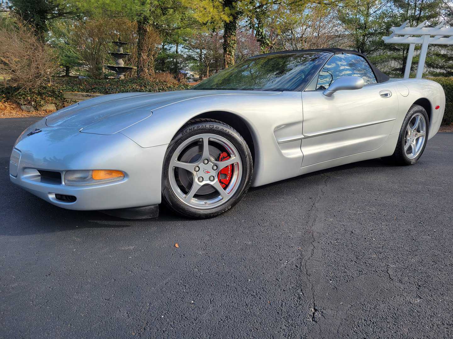 A Silver 2001 Chevrolet Corvette Parked In A Parking Lot.