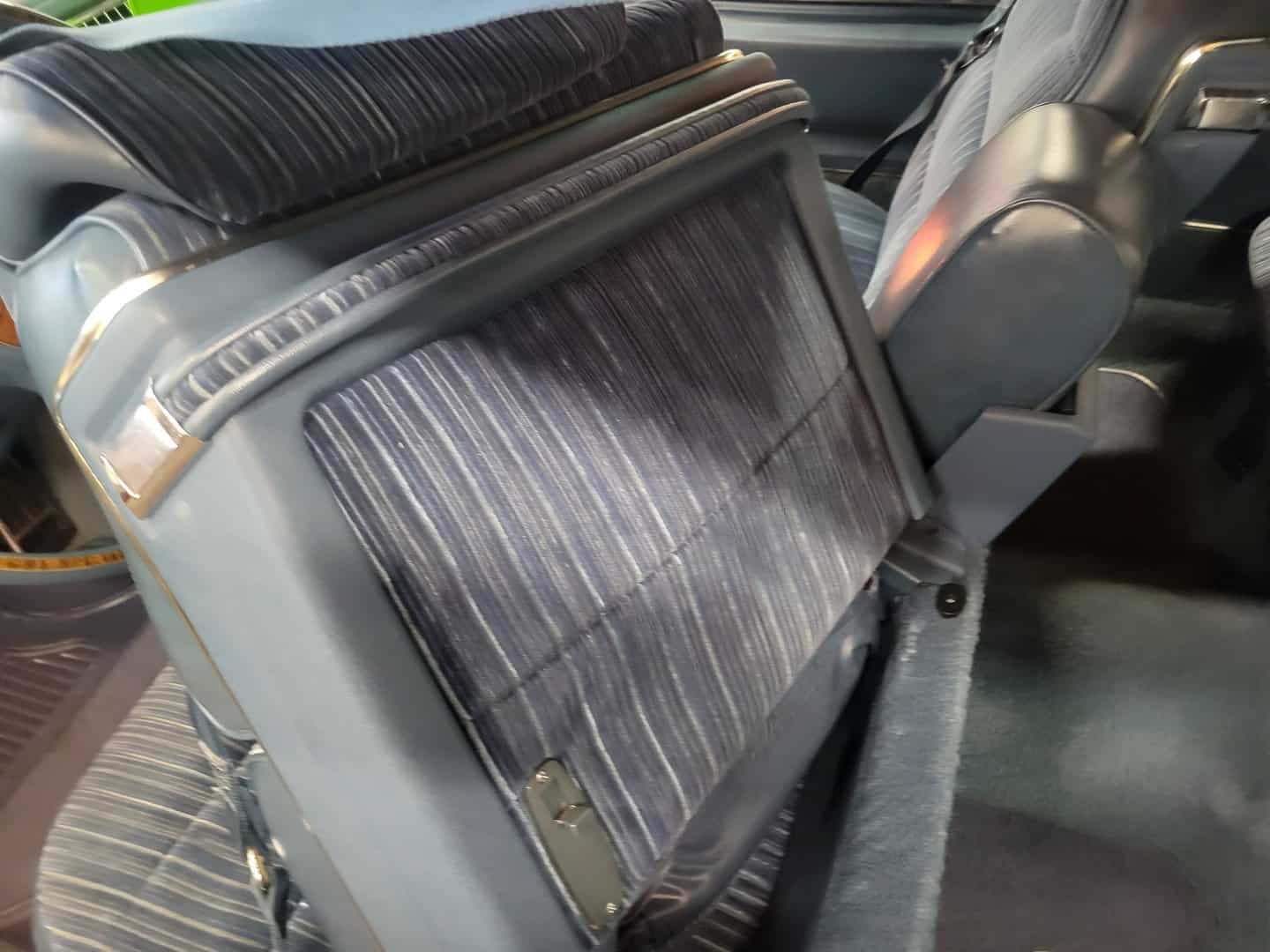 The Back Seat Of A 1976 Cadillac Coupe Deville With A Seat Belt.