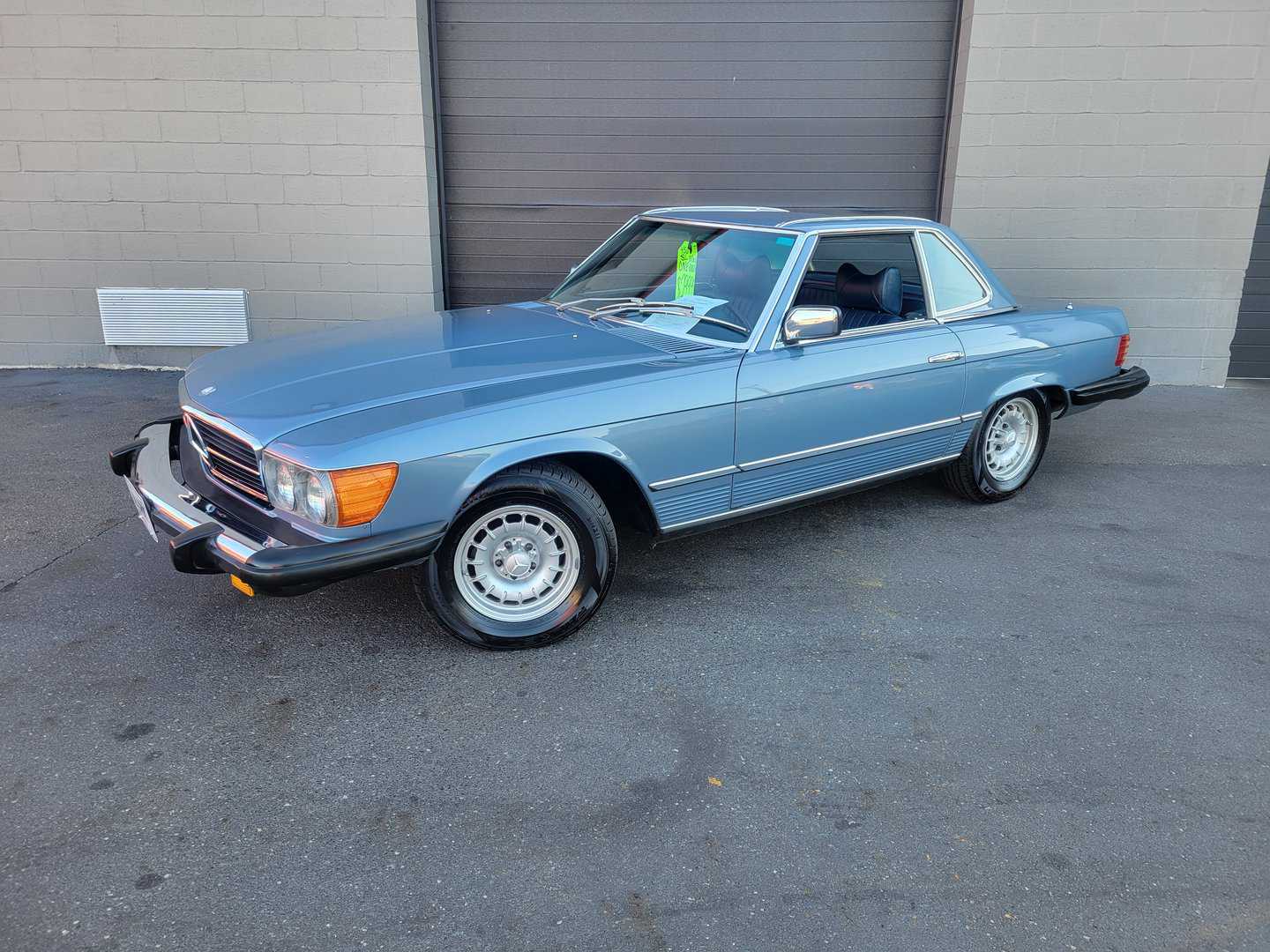 A Blue Mercedes Benz 450 Sl Is Parked In Front Of A Garage.