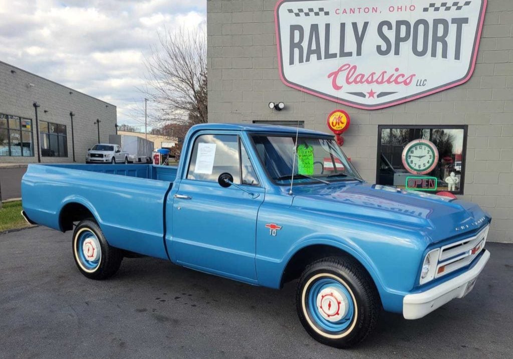 A Blue Chevrolet C/10 Pick Up Truck Is Parked In Front Of A Rally Sport.