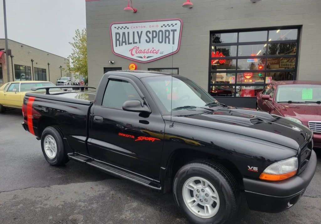 A 1997 Dodge Dakota Sport truck is parked in front of a sports store.